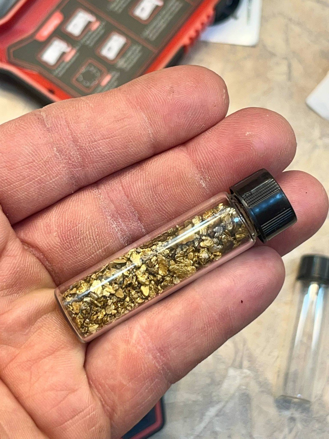 Recovered placer gold in sample vial